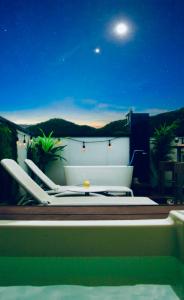 岐阜Vacanza Resort的几个躺椅在晚上坐在阳台上