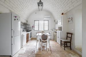 奥斯图尼Buenaventura House by Typney的厨房配有白色家电和桌椅