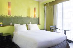 圣地亚哥蓝树创始人酒店的一张大白色的床,位于带桌子的房间