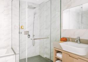 迪拜Sonder Downtown Towers的一间带玻璃淋浴和水槽的浴室