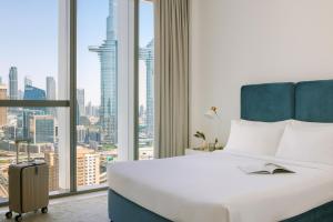 迪拜Sonder Downtown Towers的酒店客房设有一张床和一个大窗户