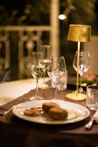 维泰博Alla Corte Delle Terme Resort的一张桌子,上面放着一盘食物和酒杯