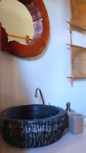 卡拉伊瓦Afeto Caraíva的浴室设有大岩水槽和镜子