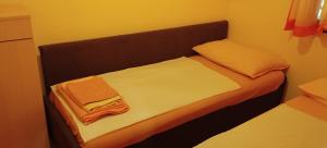 大洛希尼Apartments Velo的小房间的小床,带毛巾