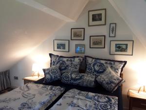 UtersumDas Rosenhaus的一间卧室配有一张带蓝色和白色枕头的床