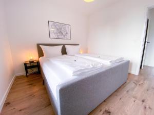 诺伊斯Schöne Wohnung mit Rheinblick/Düsseldorf/Neuss/Messe的一张带白色床单和枕头的床