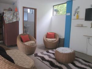 巴尼奥斯CASA MARTIN en Baños de Agua Santa的客厅配有三把椅子和地毯