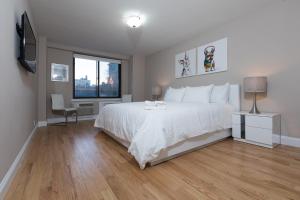 纽约Awesome 2 Bedroom Apartment in NYC的卧室配有白色的床和窗户。