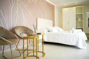 佩斯基奇Sirena Suite Deluxe的一间卧室配有一张床、两把椅子和一张桌子