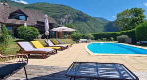 杜萨尔Manou du Lac Annecy的一组椅子和一个享有山景的游泳池