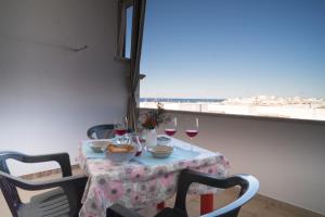 维拉诺瓦Monolocale ilporticciolovacanze的一张桌子和酒杯,享有海景