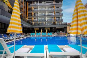 阿拉尼亚阿西酒店的一个带躺椅的游泳池和一间酒店