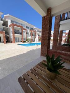 蓬塔卡纳Casa Mulata Coral Village Pool & Playa 2的坐在大楼前的木凳