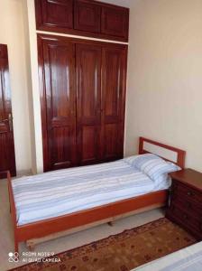Souira GuedimaGrand appartement à deux pas de la plage的一间卧室配有一张带木制橱柜的床和梳妆台。