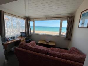 博格诺里吉斯Navigator Hotel的带沙发的客厅,享有海滩美景