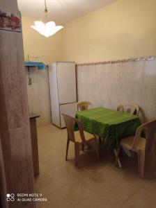 Souira GuedimaGrand appartement à deux pas de la plage的厨房配有桌椅和冰箱。