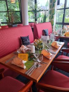 巴特嫩多夫伊斯帕拉德大酒店的餐厅里一张木桌,配有红色椅子
