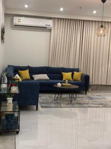 阿可贺巴Family Furnished Apartment in Khobar的客厅配有蓝色的沙发和桌子