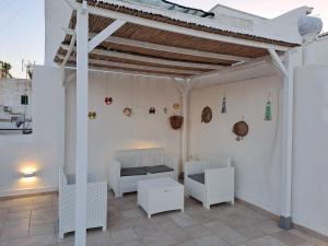 加利波利Le Terrazze di Scirocco的庭院内白色凉亭和白色家具
