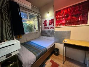 香港云吞面的小房间设有一张床和一张书桌
