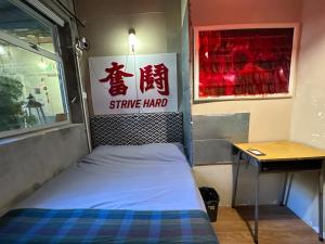 香港云吞面的墙上有标牌的房间的一张床位