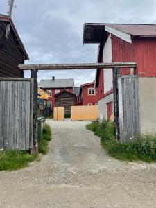 勒罗斯Kjerkgata 6 - midt i Røros sentrum的院子里有两扇木门的旧谷仓