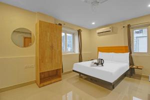 海得拉巴Super Townhouse 733 Whiteridge Gachibowli Near AIG Hospital的卧室配有白色的床和镜子