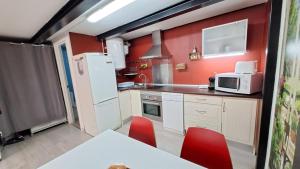 马德里La Vaguada loft的厨房配有白色冰箱和红色墙壁
