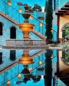 LemosCasa Colonial San Alejo的水面上反射的建筑物前的喷泉