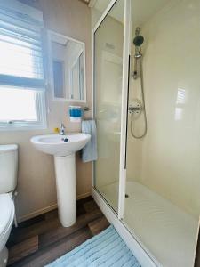 南塞尔尼Summer Breeze-Hoburne Cotswolds的带淋浴、盥洗盆和卫生间的浴室