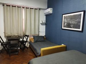 里约热内卢Residencial Praia do Flamengo - Zona Sul Rio de Janeiro的客房设有一张床和一张桌子及椅子