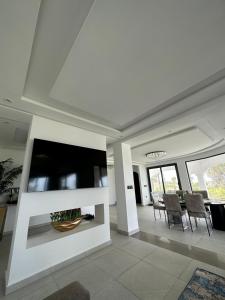 Jebel ZemzemVilla Marina Hills - Tamuda Bay的客厅配有大电视和椅子