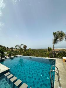 Jebel ZemzemVilla Marina Hills - Tamuda Bay的一个种有棕榈树的大型蓝色游泳池