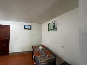 帕帕亚克塔Hermoso departamento en el corazón de Papallacta的一间墙上有一张桌子和两张照片的房间