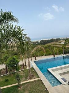 Jebel ZemzemVilla Marina Hills - Tamuda Bay的一座棕榈树和海洋游泳池