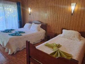 安加罗阿Hostal Avareipua的配有弓的酒店客房内的两张床