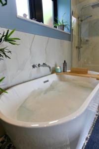 哈沃斯Farways Den的浴室设有白色浴缸及镜子