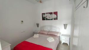 El AlquiánApartamento en Costacabana的一间小卧室,配有一张带红色毯子的床