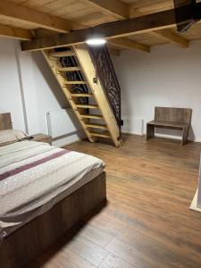 图尔达Wineyards Salin的一间卧室设有一张床和木制楼梯