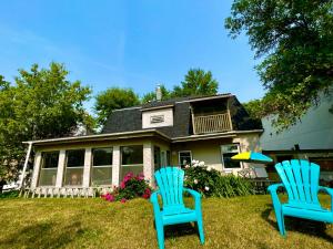 温尼伯River view house的两把蓝色椅子坐在房子前面的草上