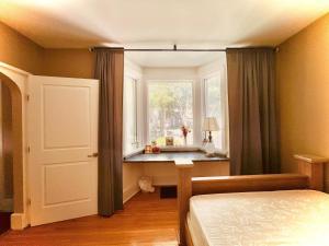 温尼伯River view house的一间卧室设有窗户、一张床和一个窗户。
