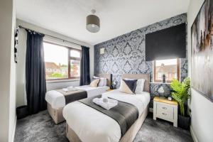 考文垂LOW RATE - Coventry for 3 BedRoom House with Garden, FREE Netflix and Unlimited Wi-fi - Driveway Parking - AGC的一间卧室设有两张床和窗户。