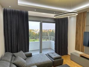 乌尔齐尼Enigma Apartment的带沙发和大窗户的客厅