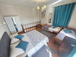 古维亚Alegria House 150m from the beach的一间卧室设有两张床和蓝色窗帘