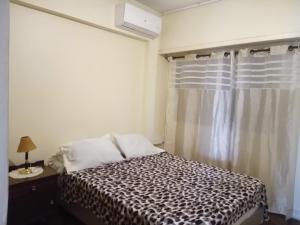亚松森Apartamento en Asunción amoblado y equipado的一间卧室配有床和带窗帘的窗户