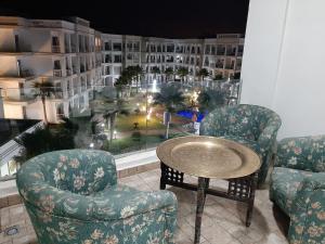布兹尼盖COSTA BEACH Lux Family Apartment with Pools的客房设有两把椅子、一张桌子和大窗户