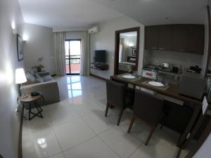 巴西利亚Bonaparte Excelente Apartamento #503的厨房以及带桌椅的起居室。