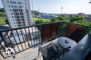 雅戈丁那Petković apartmani 34的一个带桌椅的阳台和一座建筑