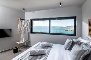 阿基欧斯尼古拉斯Beachfront Salty Sea Luxury Suite 2的一间卧室设有俯瞰水面的大窗户