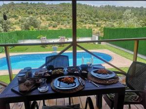 Hakuna Matata Tiny House Urla / Özel Havuzlu的一张桌子,上面有食物,享有游泳池的景色